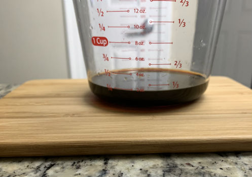 Dark marinade ingredients measured in a clear cup