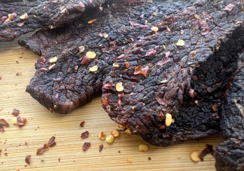 Close-up of dark beef jerky with crushed red pepper
