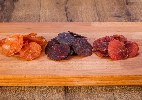 Three groups of dried meat pieces arranged on a board