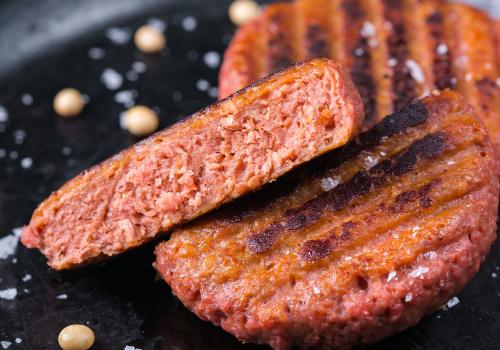 Grilled patties with one cut open to show the center