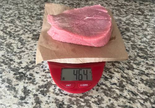 Raw beef weighed on a digital kitchen scale