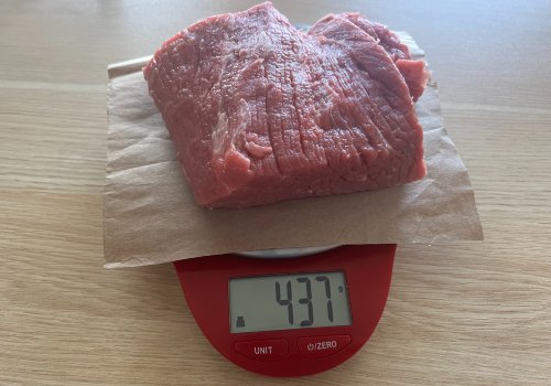 Raw beef on a scale reading 437 grams