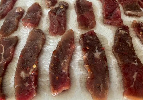 Marinated beef strips resting separately on paper towels