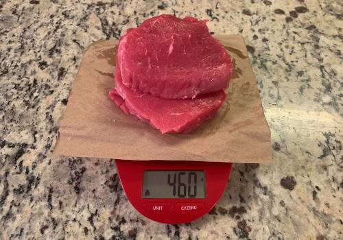 Raw beef on a scale reading 460 grams