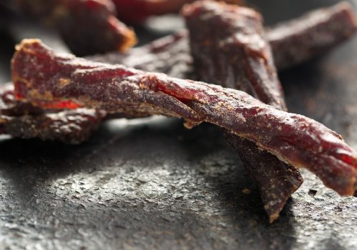 Close-up of dried meat strips with light patches on the surface