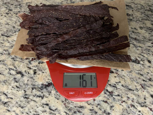 Finished jerky on a scale reading 161 grams