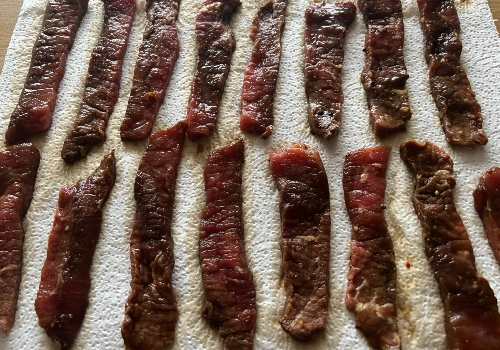 Marinated beef strips draining on paper towels