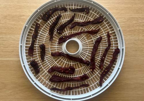 Finished New Mexico-style jerky strips on a white tray