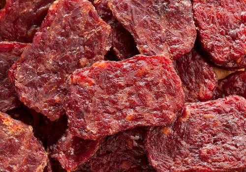 Close-up of small red dried meat pieces