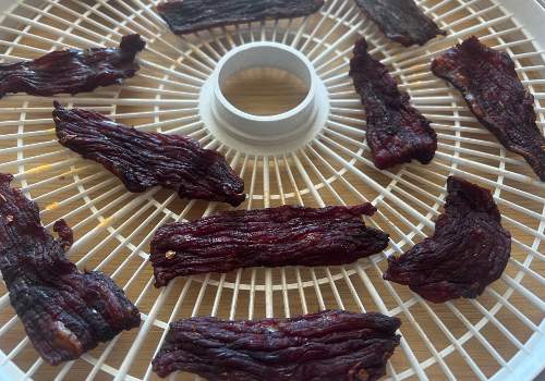 Darkened old-fashioned jerky pieces on a round tray