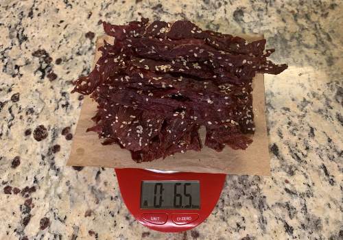 Finished sesame jerky on a scale showing 6.5 ounces