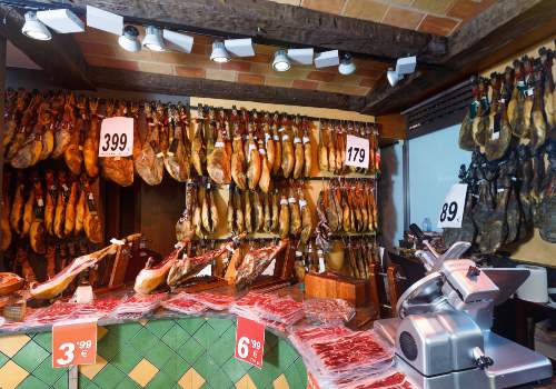A market stall displaying hanging cured meats and sausages