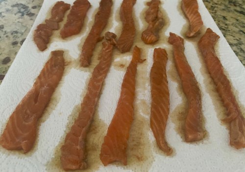 Marinated salmon strips draining on paper towels