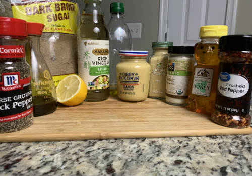Brown sugar, lemon, pepper and bottled seasonings on a cutting board
