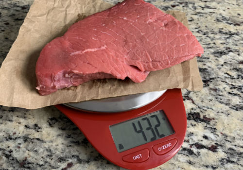 Raw beef on a digital scale reading 432 grams