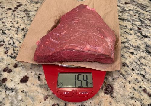 Trimmed raw beef on a scale reading 15.4 ounces