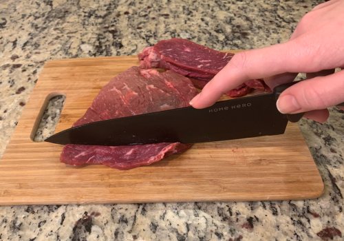 Knife cutting beef into thin slices