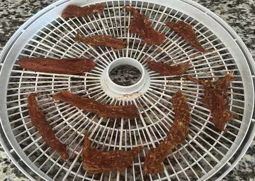 Dried turkey jerky on a dehydrator tray