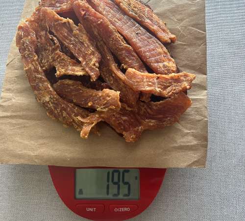Finished turkey jerky on a scale reading 195 grams