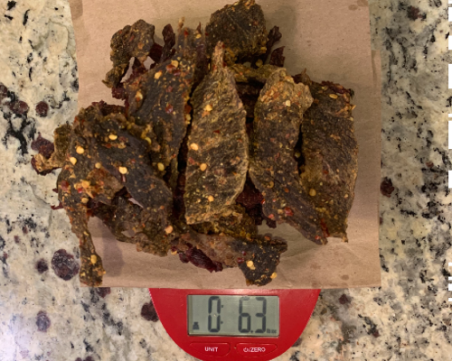 Finished beef jerky on a scale set to ounces