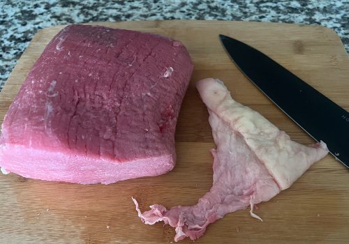 Cutting off fat from our choice of beef - eye of round