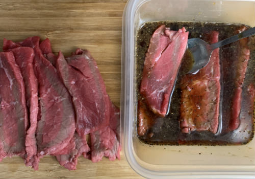 Mixing the marinade and meat for peppered beef jerky