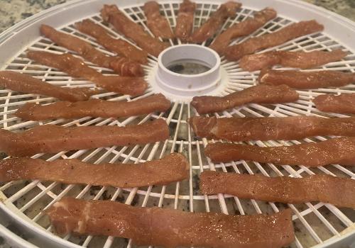 Pork placed on the dehydrator for drying