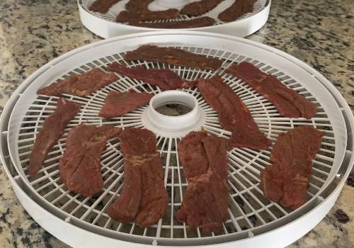 Sweet heat beef jerky placed on the dehydrator for drying